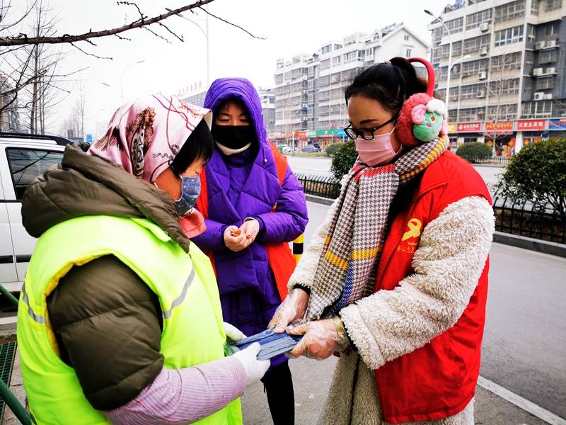 华川党员先锋队在街头为交警,环卫等一线工作者送上捐赠口罩的新闻